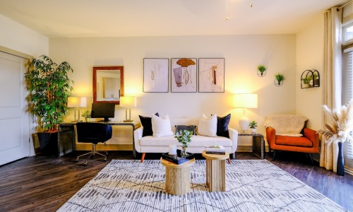 living room with a couch, chairs, and large plant