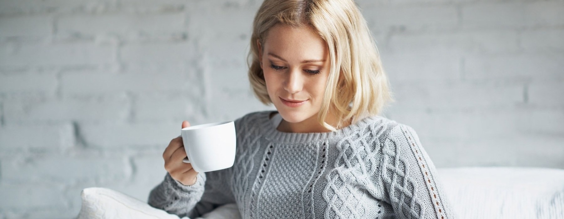 woman on couch with a cup of coffee