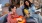 a person playing a guitar next to a person sitting on a couch