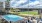 a swimming pool with chairs and umbrellas next to a large building